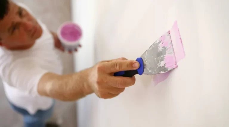 guy applying plaster on stucco wall